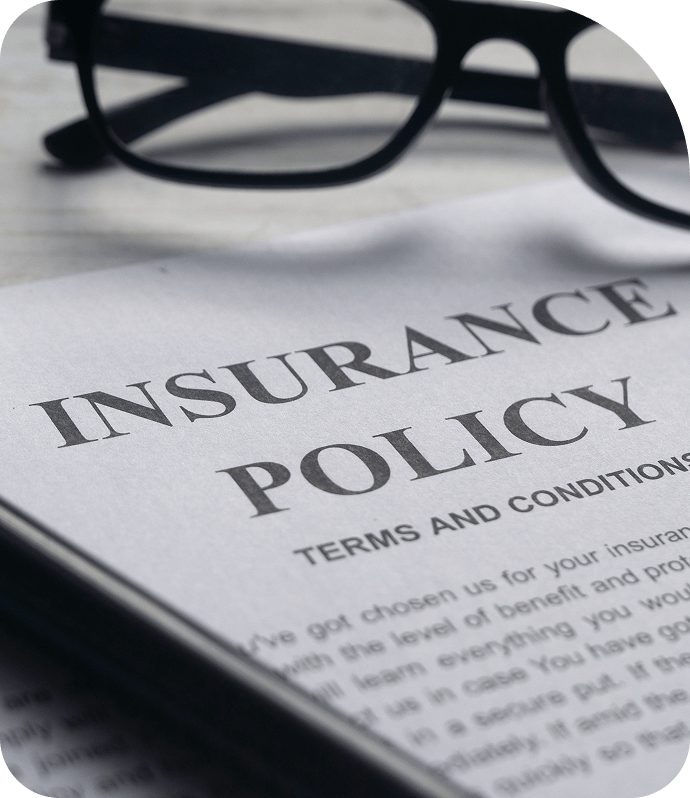 Insurance policy document with reading glasses nearby.