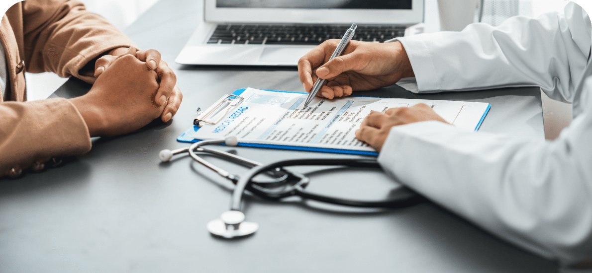 Doctor writing on clipboard during consultation.