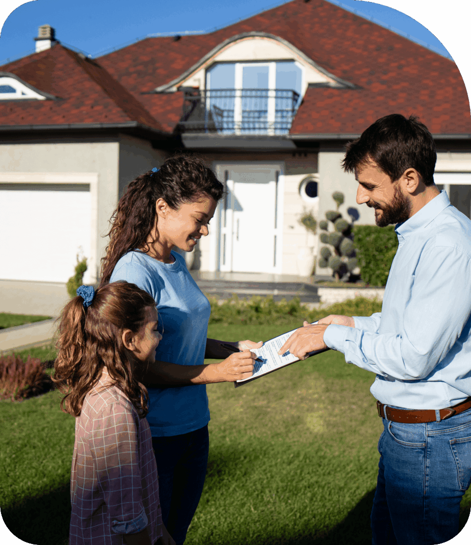 Family signing documents in front of house.